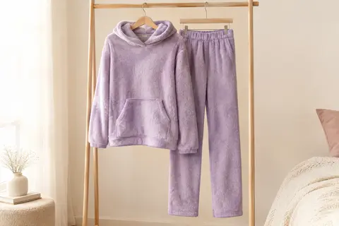 Pyjama femme en polaire avec haut à capuche et bas assorti, présenté seul sur un cintre.