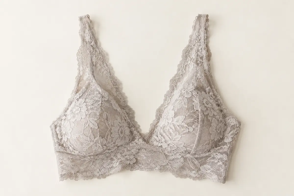 Brassière sans armature en dentelle florale, présentée à plat sur un fond ivoire lumineux